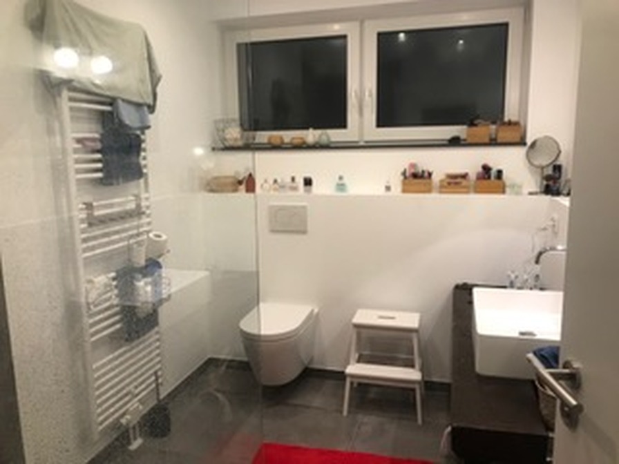 Fertiges modernes Badezimmer mit WC, Waschtisch, Handtuchheizkörper und Dusche